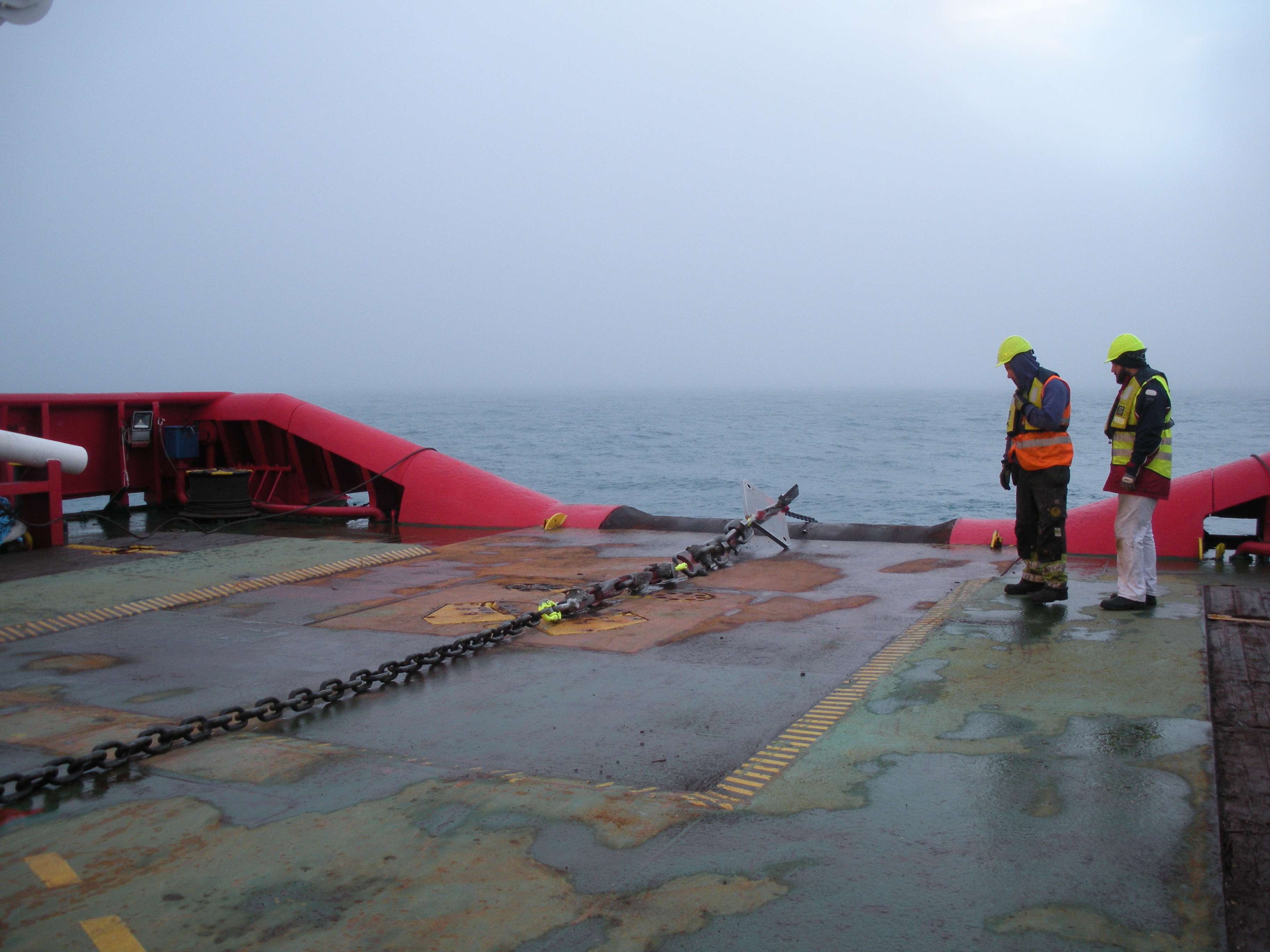 Personal offshore durante una maniobra de cubierta con cadena de ancla